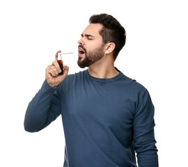 Young man using throat spray on white background