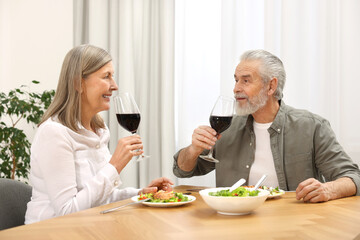 Happy senior couple having romantic dinner at home