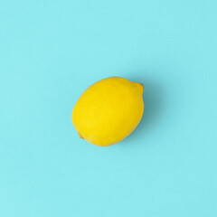 Fresh lemon on bright blue background. Minimal food concept. Fruit flat lay.