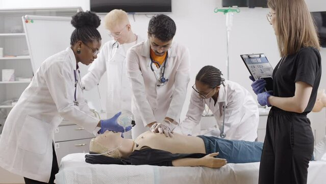 Medical professionals conduct examination on medical dummy at a first aid course