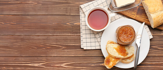 Composition with tasty pear jam, tea and toasts on wooden background with space for text, top view