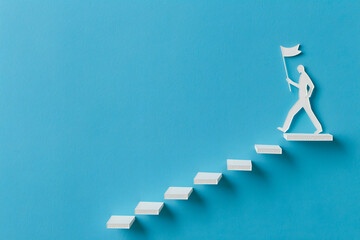 Leadership and success concept. Businessman standing on the top of stairs and holding flag.