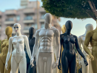 A diverse lineup of mannequins in different finishes stands poised against an urban backdrop,...