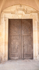 Fototapeta na wymiar Puerta de madera tallada con formas gráficas en edificio antiguo