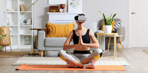 Sporty young woman in VR glasses  meditating at home