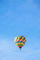Fototapeta na wymiar Colorful hot air balloon flying across the blue sky