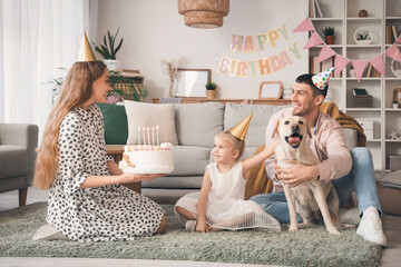 Happy family with cake and Labrador dog celebrating Birthday at home