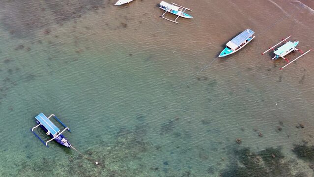 Aerial 4K footage of traditional Indonesian fisher boats floating on waves in Lombok island coastline. Drone video
