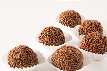 Chocolate truffle ball Brigadeiro brazilian candy and chocolate flakes aerial view clean background