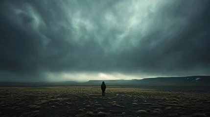 Foto op Canvas Person standing alone in a vast, desolate landscape with a stormy sky overhead, representing the emotional isolation and unease associated with feeling abashed.  © Oskar Reschke
