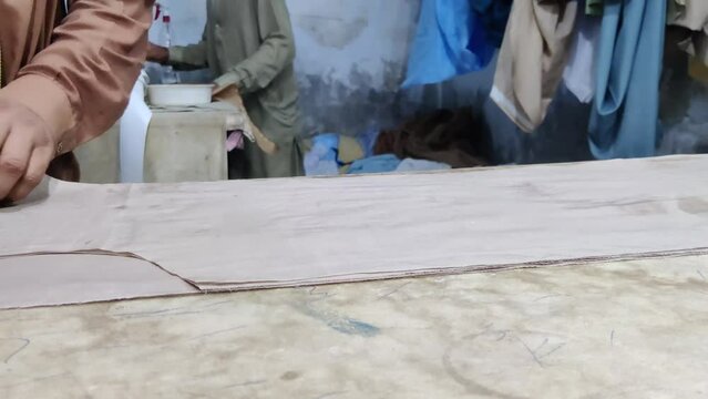 Skilled tailor meticulously cutting cotton cassock fabric with precision