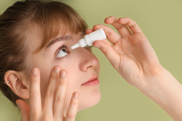 Young woman using eye drops on green background, closeup. Glaucoma awareness month