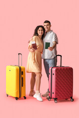 Couple of tourists with passports and suitcases on pink background