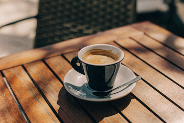Cup of black coffee on a table in a street cafe.
