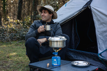 vertical portrait Camper Enjoying Coffee While Cooking Outdoors in Nature