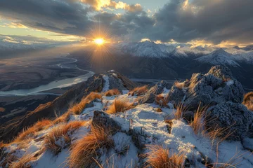 Schilderijen op glas Sun sets behind snowy mountain, casting warm light on cold landscape © Gromik