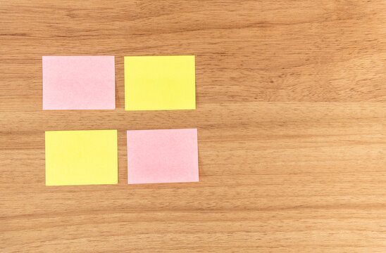 Post it, papel de recado sob fundo de madeira bege. Amarelo rosa. quatro papeis, espa&ccedil;o para deixar recado, escrever noticia, redes sociais