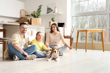 Happy family with Beagle dog sitting in kitchen on moving day