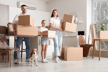 Fototapeta na wymiar Happy family with boxes and Beagle dog in kitchen on moving day