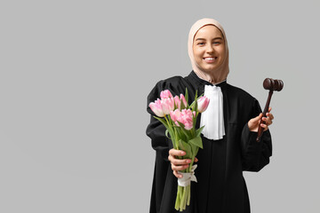 Muslim female judge with pink tulips on white background. Women's Day celebration