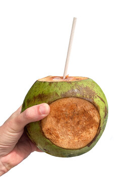 Male hand holding an iced coconut with a paper straw with a cut on the side for inserting text or logo. Transparent background.