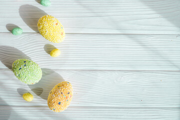 Colorful Easter eggs on a wooden table. Easter concept flat lay with copy space.