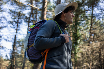Explorer Trekking in Forest Wilderness with hat and backpack