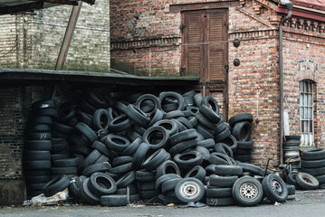 Pile of Used Tires Against a Brick Wall in Gothenburg, Sweden at Dusk