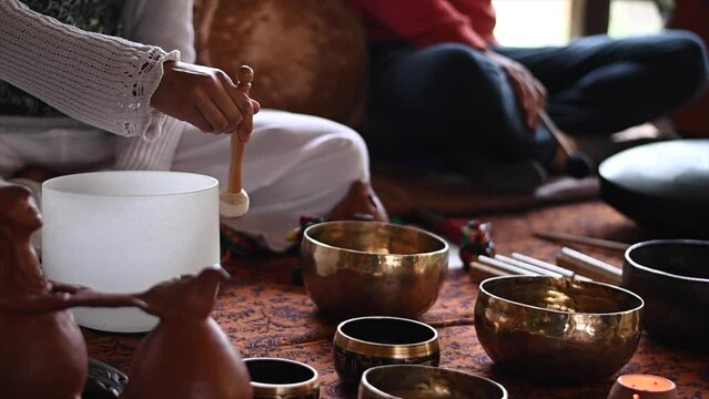 slow motion of hand making sounds with tibetan bowls harmony and health with space for text