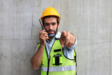 The gesture of a male engineer posing with a walkie-talkie. Strike a pose of a male engineer using a walkie-talkie.