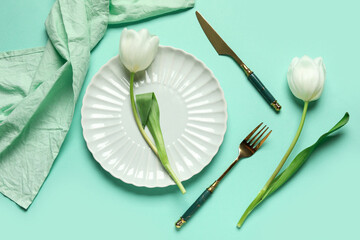 Fototapeta na wymiar Beautiful table setting with white tulips on turquoise background
