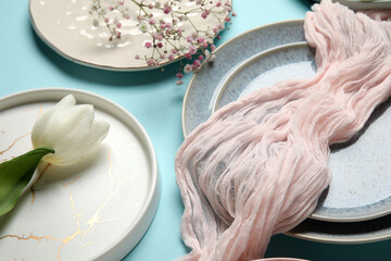 Beautiful table setting with white tulip and gypsophila flowers on blue background