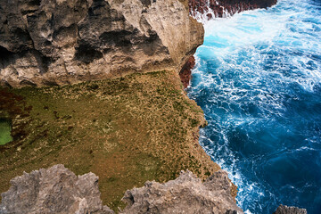 A cliff broken by an ocean wave. The cliff is washed by powerful waves of the ocean. A popular tourist destination Angel's Billabong on the island of Nusa Penida in Indonesia.