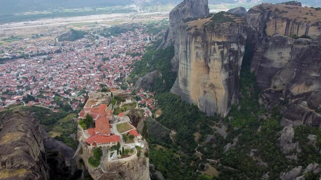 Aerial view of Monastery of the Holy Trinity (Agia Triada) in Meteora, Greece with Kalabaka town and mountains in the background