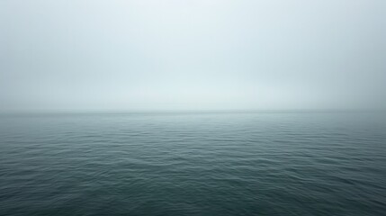   A foggy day, with a solitary boat floating on a vast expanse of water - obrazy, fototapety, plakaty