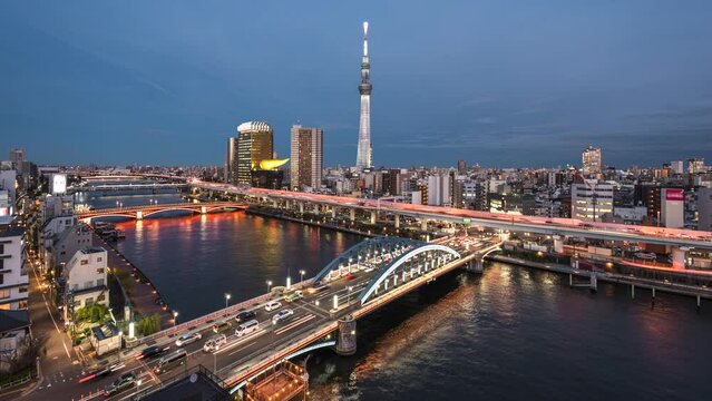 Dusk to night timelapse view of Sumida River and Tokyo skyline in Tokyo, Japan.