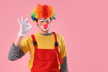 Portrait of clown showing OK on pink background. April Fool's day celebration