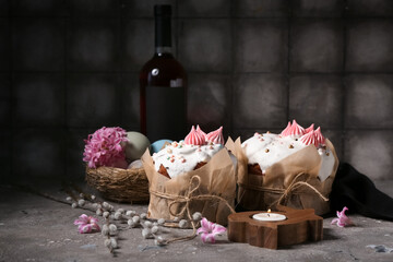 Easter cakes, painted eggs in nest, candlestick in shape of rabbit and willow branches on grunge background
