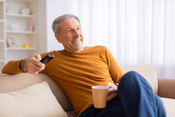 Mature man relaxing with remote and coffee