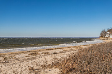 Fototapeta na wymiar Rocky and Sandy Beach Shoreline with Ocean View with Clear Blue Sky