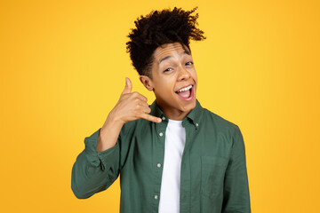 Cheerful black guy mimicking phone call