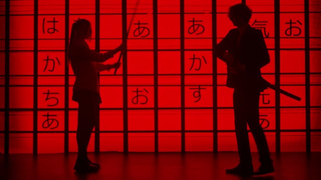 People against big digital wall in studio. Silhouettes of man and woman fighting on japanese swords katana, digital screen red asian graphic background.