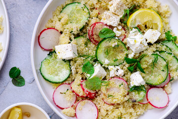 Fresh vegetable salad with couscous and feta in ceramic bowl. selective focus