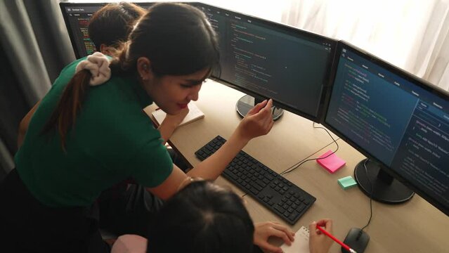 Slow motion back end software developer engineer for computer programming working together on debugging writing computing code, solving complex algorithms display on monitor in office. Burgeoning
