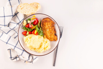 Fried chicken steak or schnitzel with mashed potatoes and vegetables salad in plate