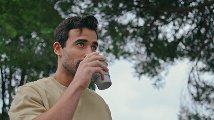 Hispanic student drinking coffee takeaway at relaxed weekend stroll closeup. 