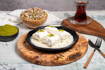Baklava with white chocolate and milk. Cold baklava with chocolate on a wooden serving board. Famous dishes of Turkish cuisine