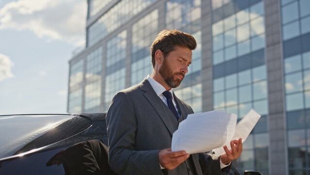 Smart lawyer analyzing documents on sunny street close up. Businessman reading