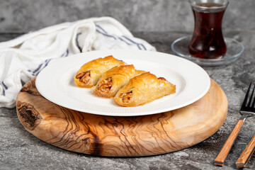 Walnut baklava. Baklava with whole walnuts and cream on a wooden serving board. Local name cevizli...