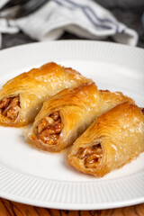 Walnut baklava. Baklava with whole walnuts and cream on a wooden serving board. Local name cevizli kelebek baklava